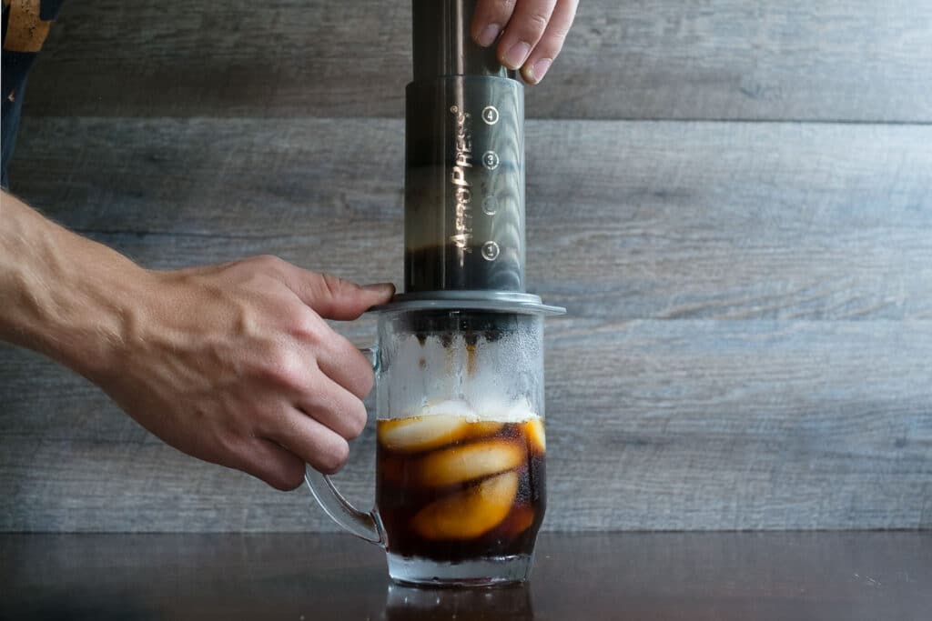 a person making cold brew coffee using an aeropress