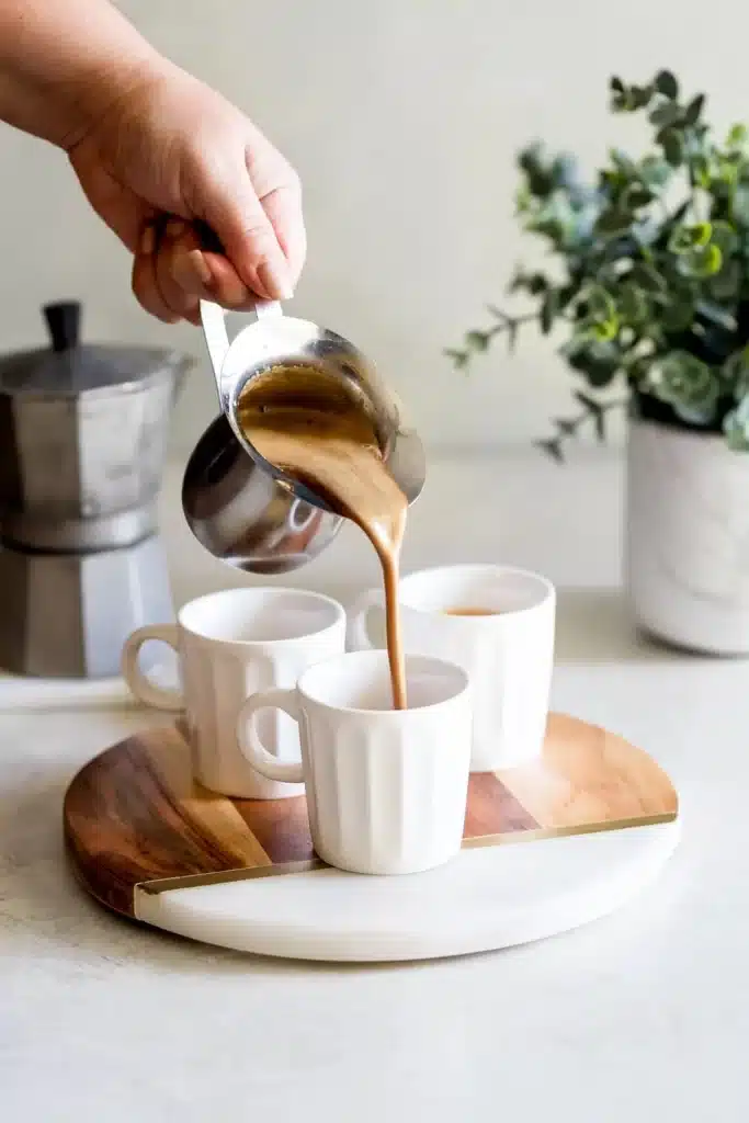 a woman pouring colada cuban coffee in cups