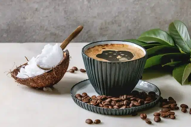 coconut oil in the mug of coffee coffee beans spread on the tray