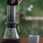 a person making coffee using an aeropress machine