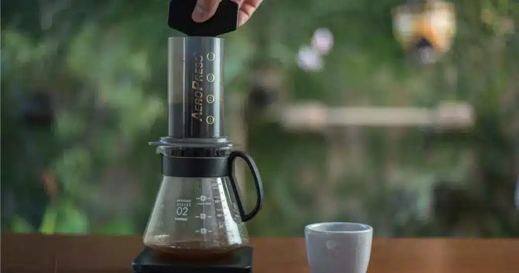 a person making coffee using an aeropress machine