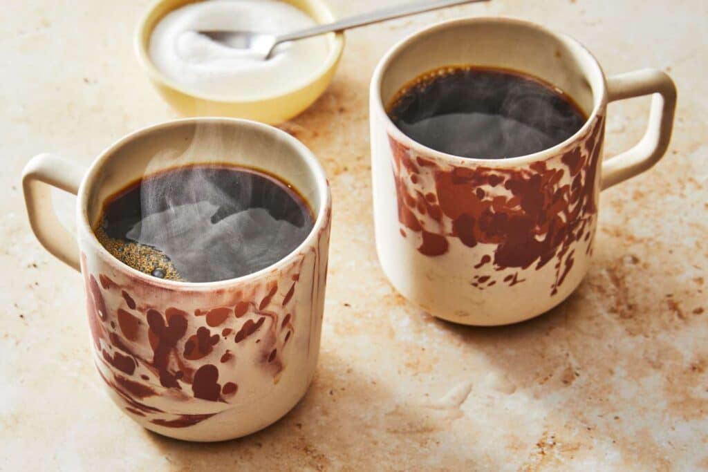 cups of coffee placeds on a marble countertop