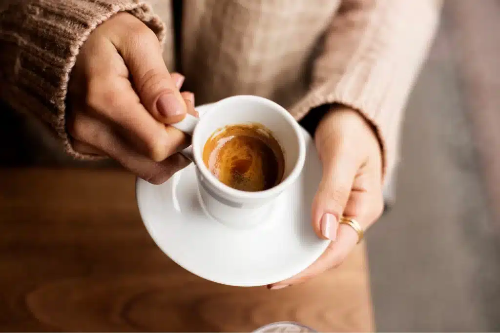 female hands carrying a cup of white coffee