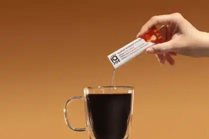 zoomed in view of female hand pouring instant coffee mixture in a cup