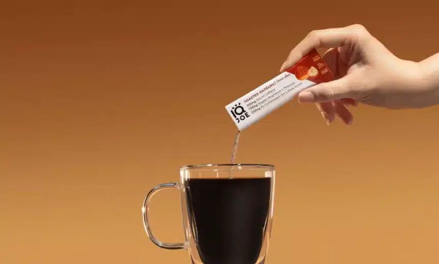 zoomed in view of female hand pouring instant coffee mixture in a cup