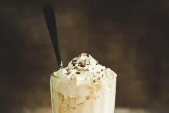 a glass of frozen coffee placed on wooden surface