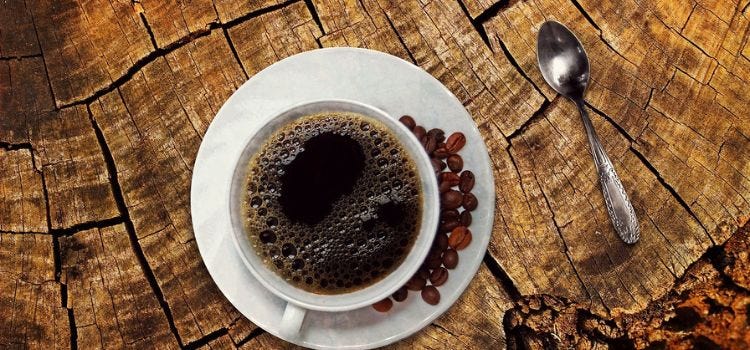 decaf coffee in cup spoon on wooden surface