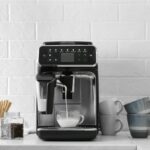 Modern Coffee Machine Pouring Milk Into Glass Cup On White