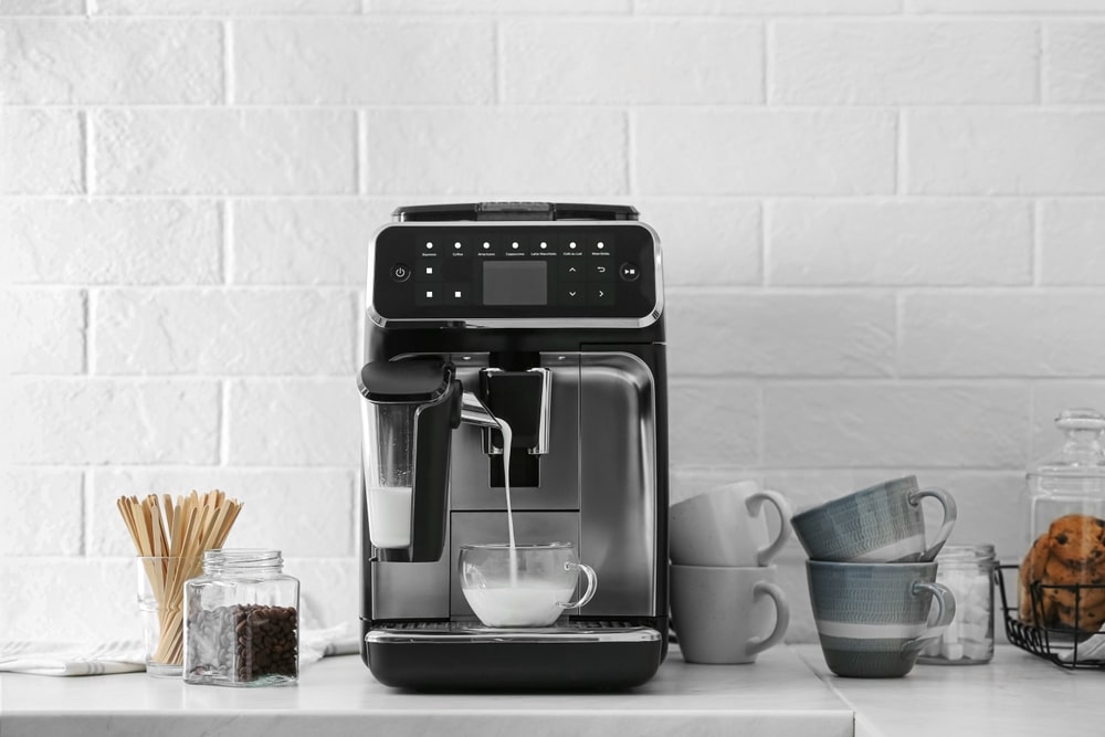 Modern Coffee Machine Pouring Milk Into Glass Cup On White