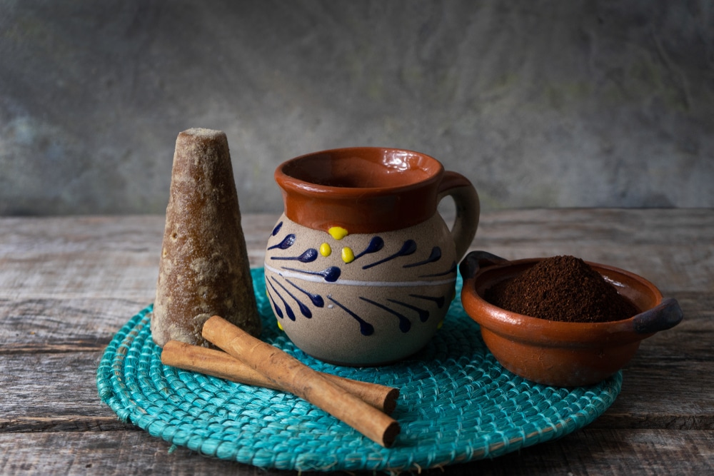 Traditional mexican cup of coffee with cinnamon on wooden background