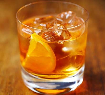 a glass of Coffee Old Fashioned  with an orange wedge