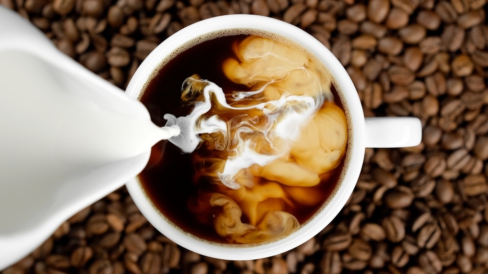 Pouring Milk In Coffee Cup Top View