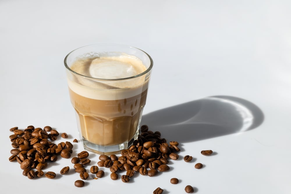 Cortado Coffee In A Glass On A Gray Background With coffee beans 