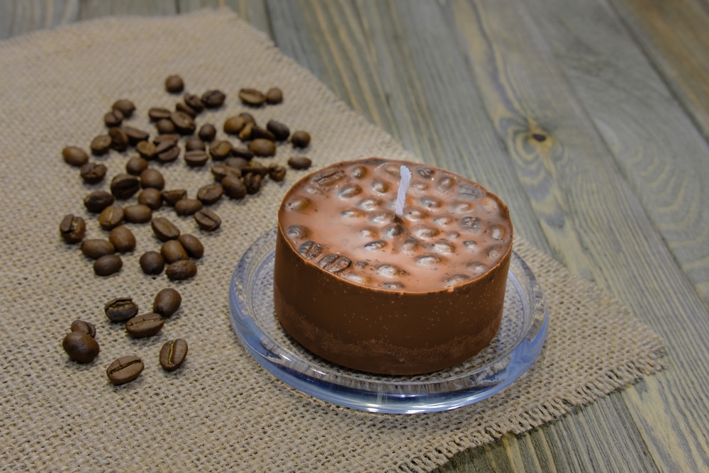 Wax Candle With Coffee Beans On A Table Covered With